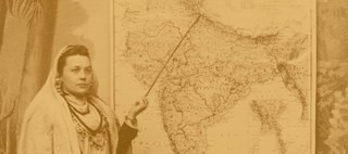En kvinna håller en pekpinne riktad mot en karta över Indien