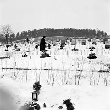 Kvinna vid grav på Skogskyrkogården.