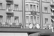 Reportage kring Kungabröllopet den 19 juni 1976. Grand Hotels fasad, smyckad med ovala porträtt av Carl XVI Gustaf och Silvia Sommerlath