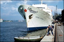 Två hamnarbetare förtöjer det ryska fartyget M/S Nadezhda Krupskaja vid stadsgården. I förgrunden en hamnroddarslup.