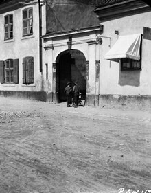 Värmdögatan 55. Vid porten mot gården står två pojkar vid en skrinda. Nuvarande Malmgårdsvägen 55