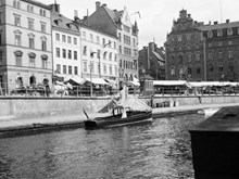 Vy från Riddarholmen. En båt ligger förtöjd i Riddarholmskanalen. T.h. Petersenska huset, Munkbron 11