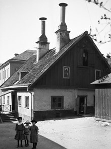Tre flickor står på gårdssidan av Värmdögatan 51 A. Nu Nytorget 13