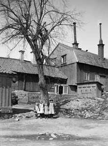 Fyra flickor på gårdssidan av Värmdögatan 61 A. Huset i bakgrunden är Värmdögatan 61, nuv. Malmgårdsvägen 61