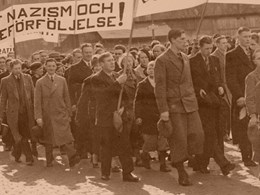 Människor går i demonstrationståg. En banderoll med texten "Mot nazism och judeförföljelse.