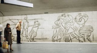 Bilden visar Östermalms tunnelbanestation och ett konstverk som är ristad på väggen