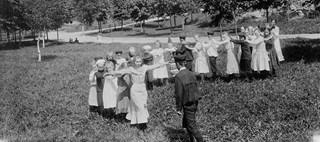 Den svartvita bilden visar barn som leker i en parkmiljö.