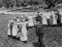 Den svartvita bilden visar barn som leker i en parkmiljö.