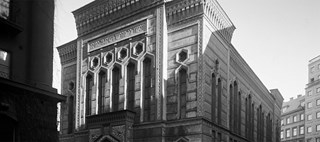 Stora synagogans fasad, med ornament runt sexkantiga fönster och hebreisk skrift ovanför portiken