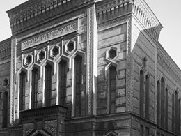Stora synagogans fasad, med ornament runt sexkantiga fönster och hebreisk skrift ovanför portiken