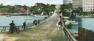 Kolorerat vykort som visar gamla Liljeholmsbron, före 1915, från söder, med Hornstullen i fonden.