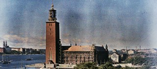Stockholms stadshus, en byggnad i tegel med högt torn vid vattnet
