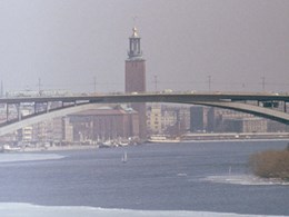 Valvbro över vatten med trafik på, i bakgrunden byggnader och torn