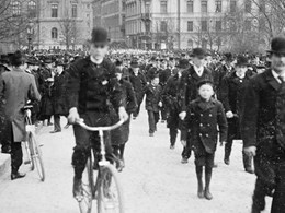 Folkmassa i Kungsträdgården. En man på cykel