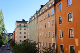 Flerbostadhus i flera färger, gata, träd, bilar