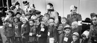 Svartvitt foto på en grupp finska flyktingbarn på en perrong