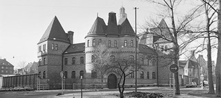Svartvitt foto av Östermalmsfängelsets fasad, en tegelbyggnad med torn.