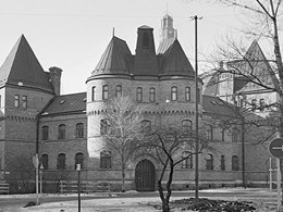 Svartvitt foto av Östermalmsfängelsets fasad, en tegelbyggnad med torn.