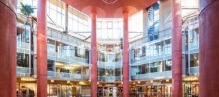 Saluhall med röda pelare, glasväggar, trappa