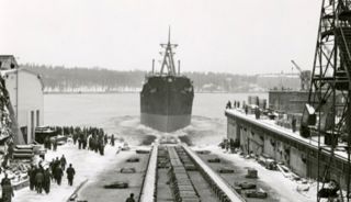 Bilden föreställer ett stort fartyg som åker ut i vattnet efter det legat inne på varvet.