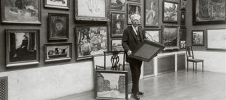 Bilden föreställer prins Eugen i sitt galleri på Waldemarsudde hållandes i en tavla.