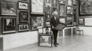 Bilden föreställer prins Eugen i sitt galleri på Waldemarsudde hållandes i en tavla.