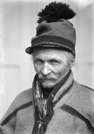 Svartvitt porträtt av äldre man i samisk kolt och mössa med tofs