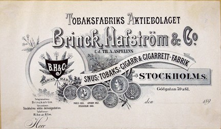 Svartvitt fakturahuvud med logotype, tobaksblommor och medaljer samt text.