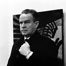 Konstnären Roland Kempe framför en av sina målningar