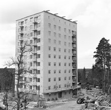 Filipstadsbacken 36. Den sydligaste stadsdelen i Stockholm byggs. Det första paret flyttar in i Farsta, Lars och Syster Klingberg tittar ut genom sitt fönster i sin 3:rummare på 9:e våningen