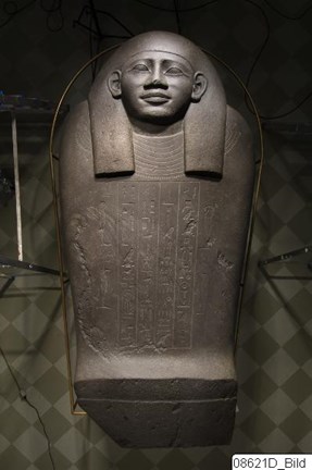 Egyptisk stenskulptur med ansikte och hieroglyfer