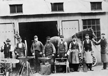 Grupporträtt med vagnmakare, smeder, hovslagare samt häst och hästskötare vid Münchenbrüggeriet.