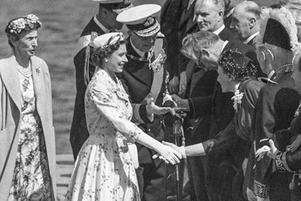 Drottning Louise av Sverige står till vänster om drottning Elizabeth II av Storbritannien som skakar hand med Ulla Lindström