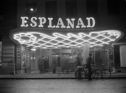 Biografens entré sedd från gatan, med rutmönstrat tag i neon.