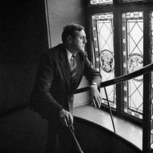 Förlagsredaktör Sven Granat poserar vid fönster i trapphuset. Sveavägen 56