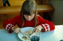 Barnens ö: Flicka äter mat