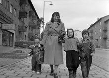 Sparbanksvägen. En kvinna med tre barn promenerar