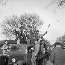 Fredsdagen den 7:e maj 1945. 
Jublande människor på lastbilsflak firar freden.