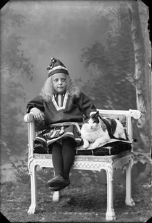 Porträtt av Maja Beckman klädd i samedräkt och tillsammas med en katt.