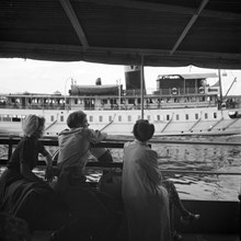 Båtar på Norrström. Passagerare sitter på däck