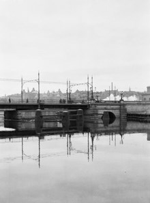 Kungsbron sedd från Kungsholms Strand. Svängbro i stålkonstruktion byggd 1881, elektrifierad 1906, riven 1944. Vasastaden i fonden