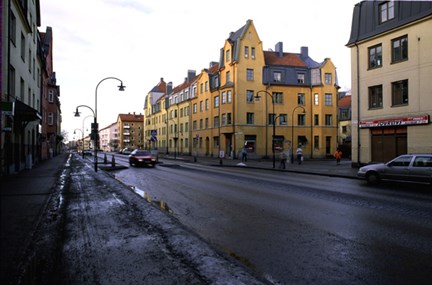 Asfalterad gatukorsning med omgivande byggnader som har putsade fasader.