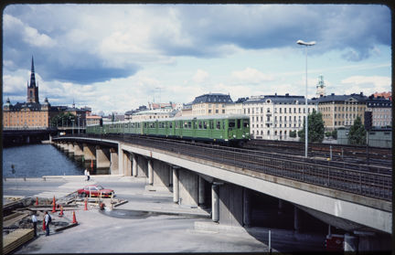 Ett grönt tunnelbanetåg åker över Söderströmsbron