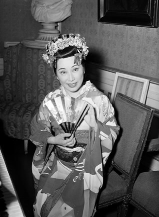 Tomiko Kanazawa iförd kimono och hårprydnad sittande på en stol.