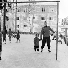 Man med barn på lekplats som spolats till skridskobana, Enskede