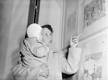 En kvinna med bebis tittar på barnteckningar på Nationalmuseum
