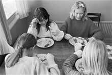 Fyra flickor vid matbord i Sätraskolans matbespisning äter korv och potatismos.