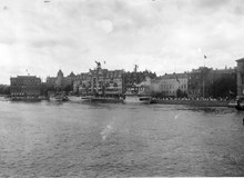 Strömmen med utsikt mot bl.a. Grand Hotel och Bolinderska huset. Det flaggas på Blasieholmen med anledning av prinsparet Gustaf Adolfs och Margareta av Connaughts hemkomst 9 juli 1905 efter deras bröllop i England.