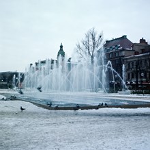 Fontänen sprutar i ett folktomt Kungsträdgården, julafton 1969. Vy åt söder, i bakgrunden Jakobs Kyrka