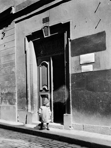 Ett litet barn står utanför porten till Svartmangatan 7, Albert Ekberghs kontor
